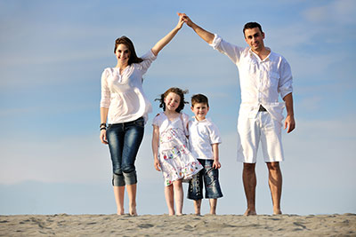 Father, Mother, Son and Daughter posing on beach