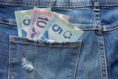 Five and Ten Dollars sticking out of jeans pocket